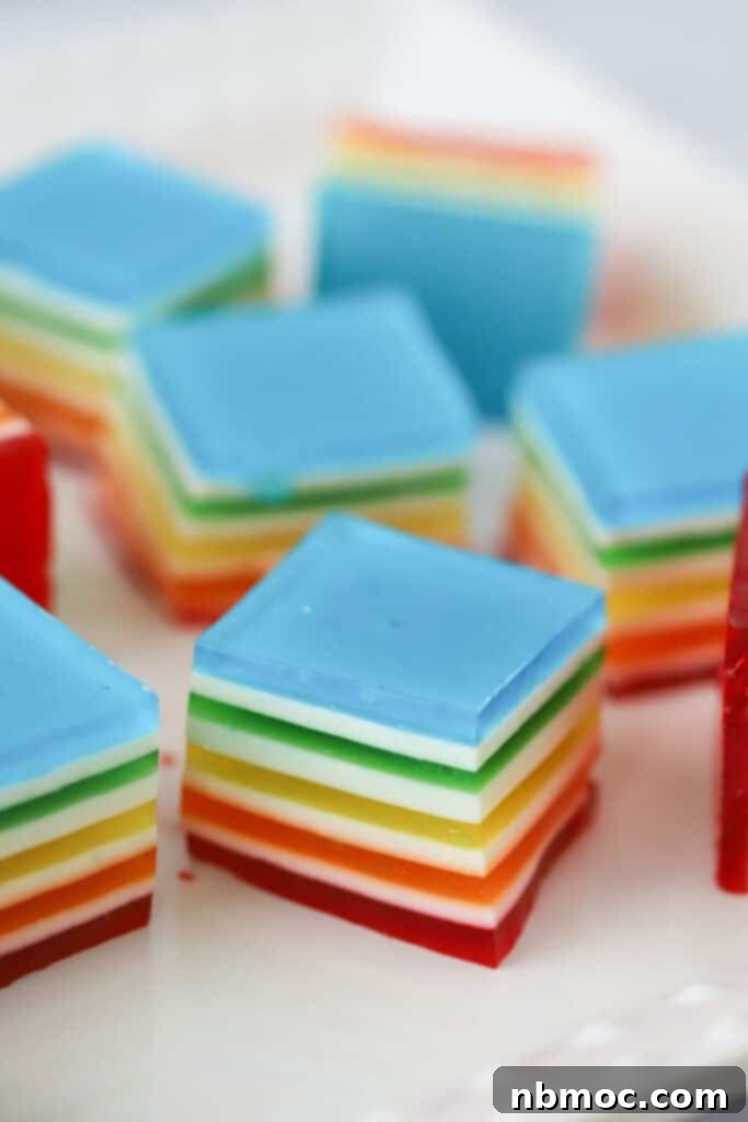 Jello Rainbow Stack 2 Squares of layered jello in rainbow colors separated by thin white layers.