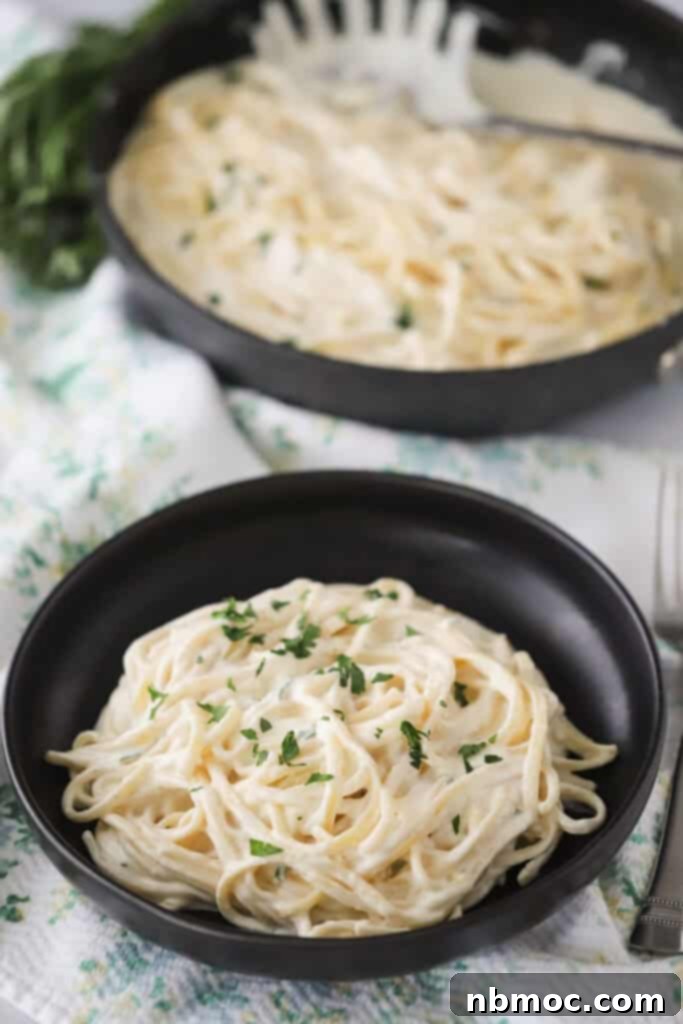 A bowl full of fettuccine alfredo with asiago sauce.