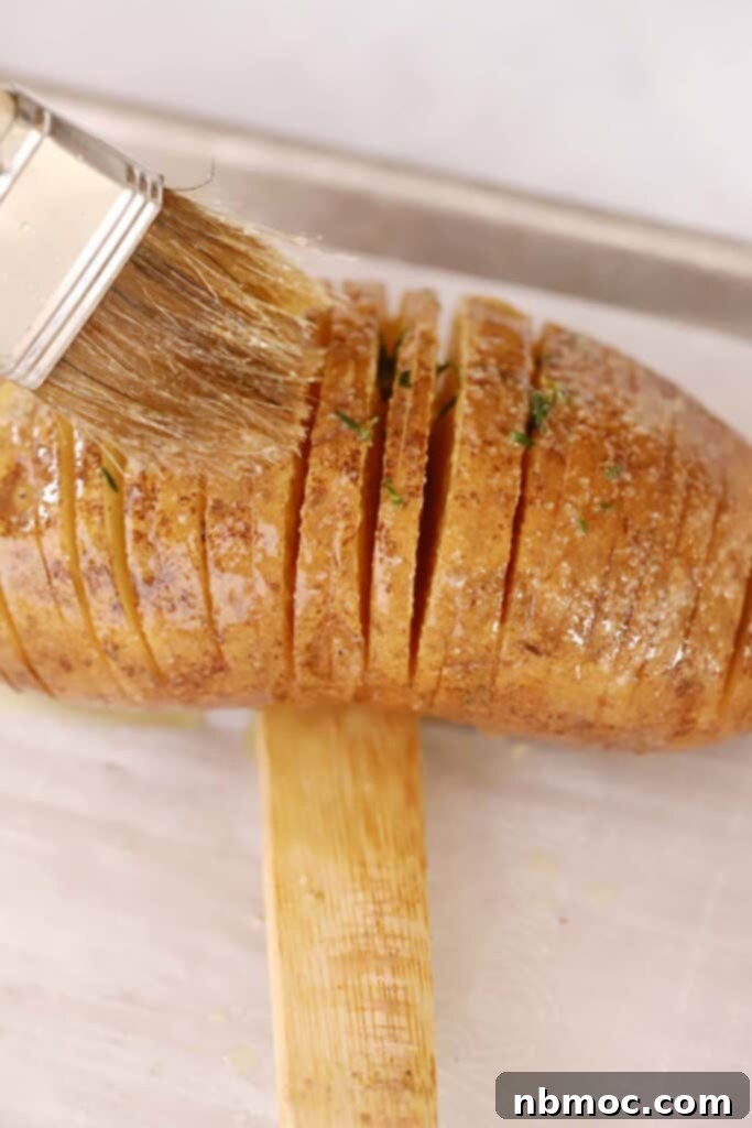 Crispy & Tender Hasselback Potatoes Made Easy 5 Brushing melted butter and oil over the top of a Hasselback Potato.