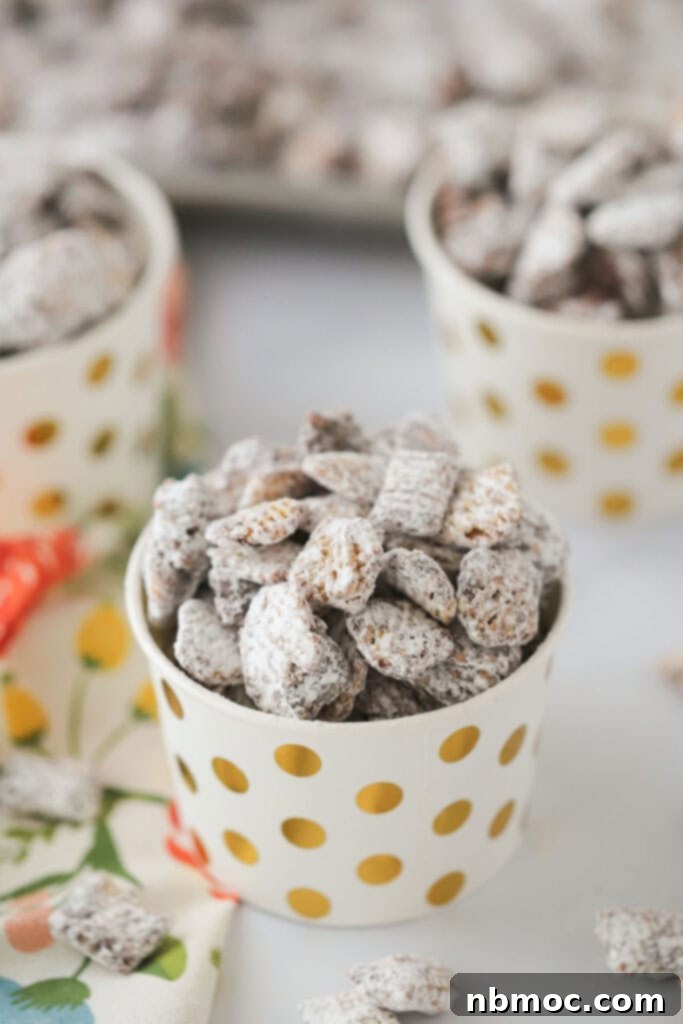 Nutella Muddy Buddies in small party cups on a tabletop, ready to be served.