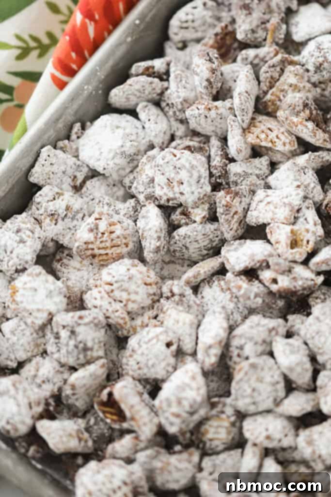 A baking sheet covered with a generous layer of freshly made Nutella Muddy Buddies.