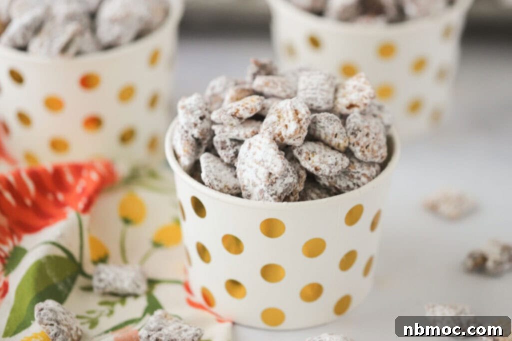 A small individual serving cup with gold dots, perfectly filled with Nutella Muddy Buddies.