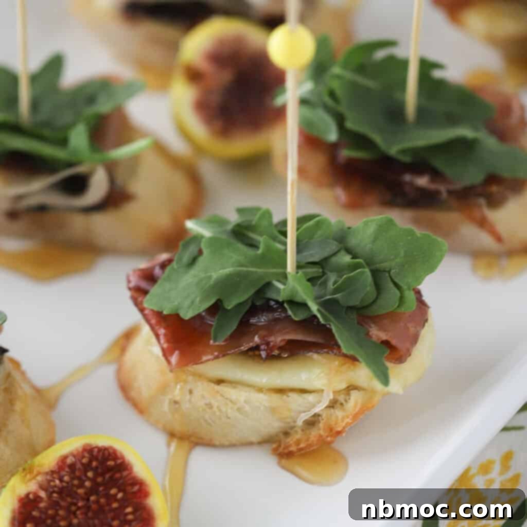 Candied figs served elegantly on a small appetizer crostini with cheese and prosciutto.