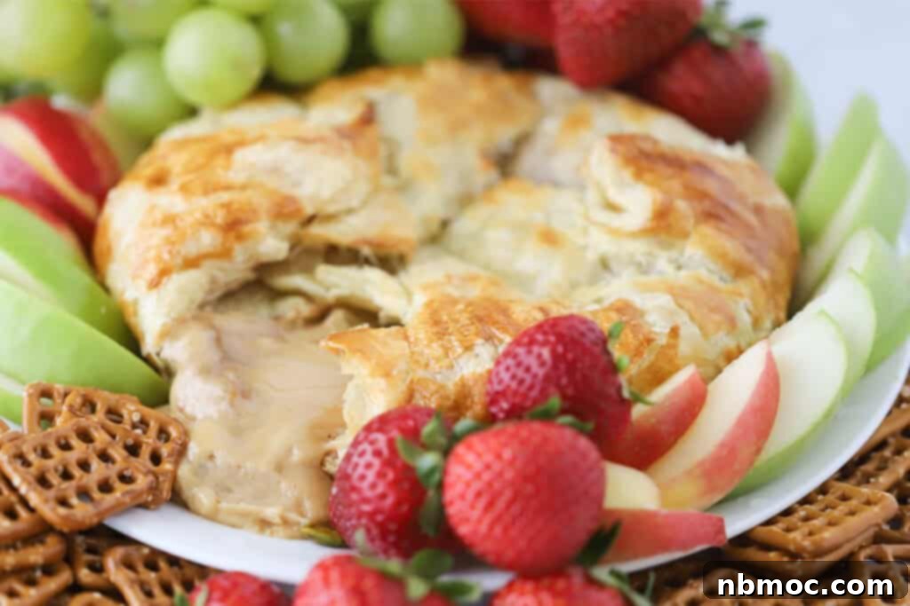 Caramel Cream Cheese Puffs 5 A festive serving platter featuring the golden-brown Caramel Cream Cheese Puff Pastry as the centerpiece, surrounded by an inviting assortment of sweet and savory dippers like pretzels, fruit, and crackers.