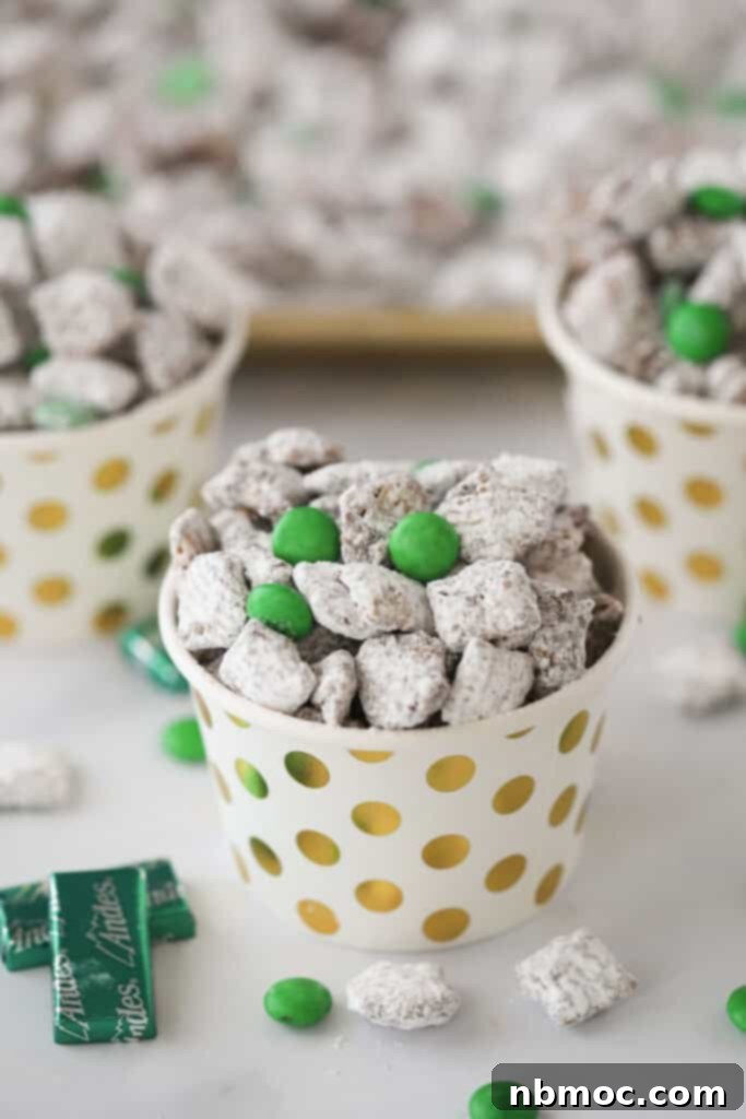 Crisp Mint Chocolate Snack Mix 2 Small decorative cups full of chocolate mint muddy buddies and green M&Ms, ready to serve.
