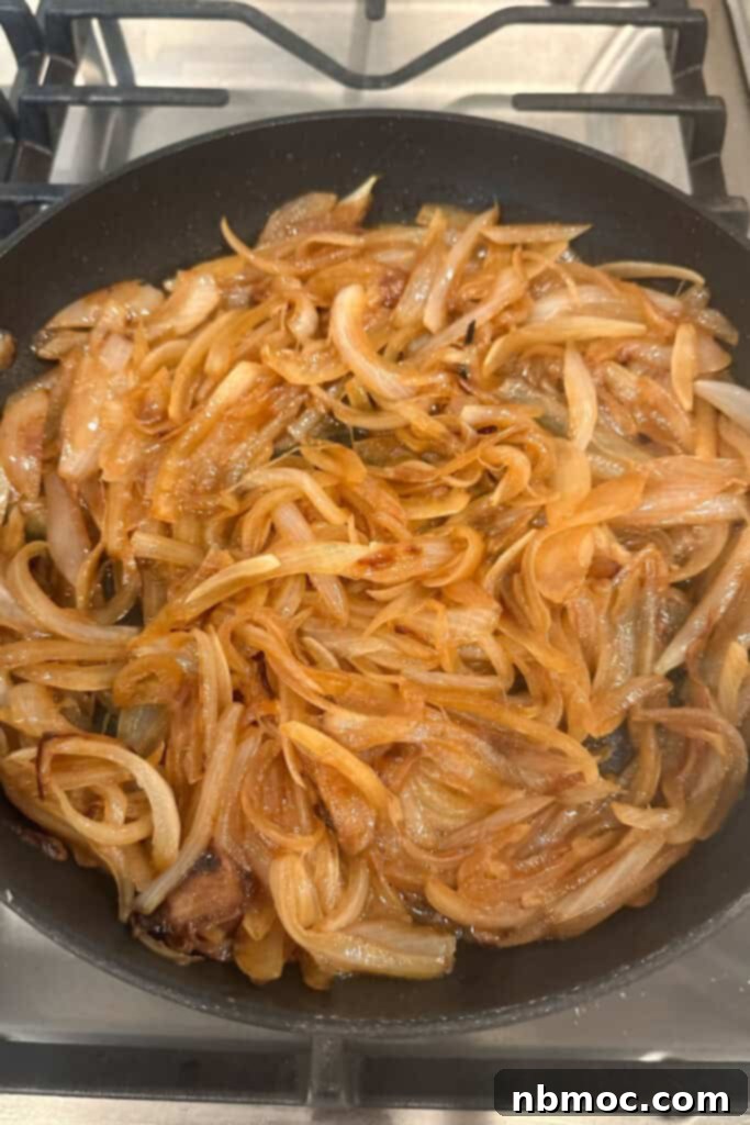 A large cast iron pan showcasing this quick caramelized onions recipe.