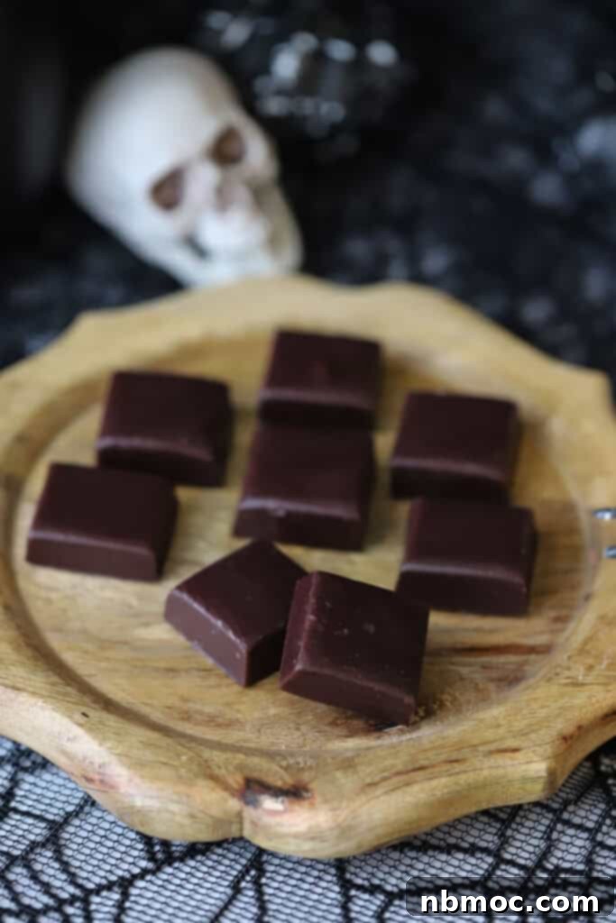 Midnight Licorice Caramels 6 Homemade caramel candies on a wooden serving tray.