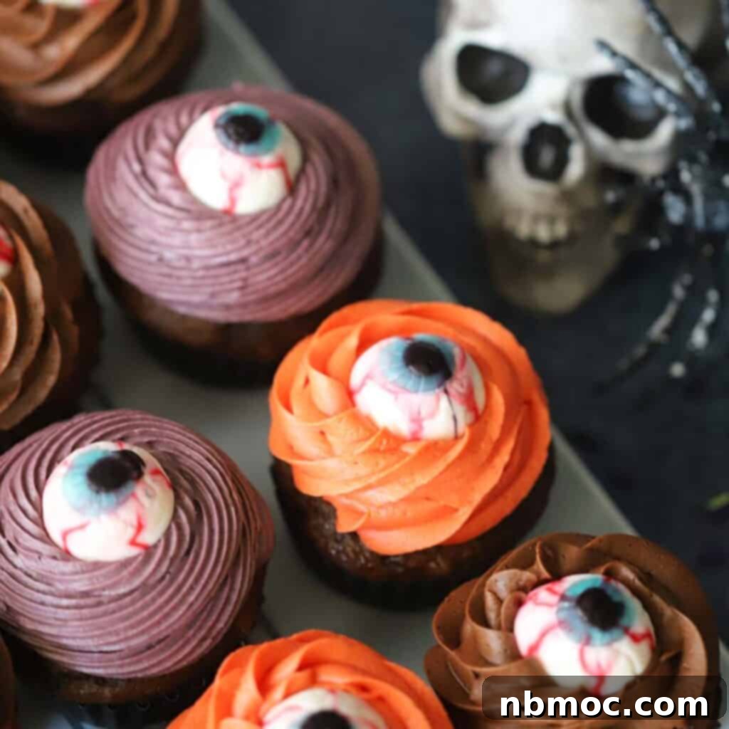 A tray adorned with cyclops cupcakes, each creatively decorated for Halloween with a single candy eye, making them a festive and spooky dessert.