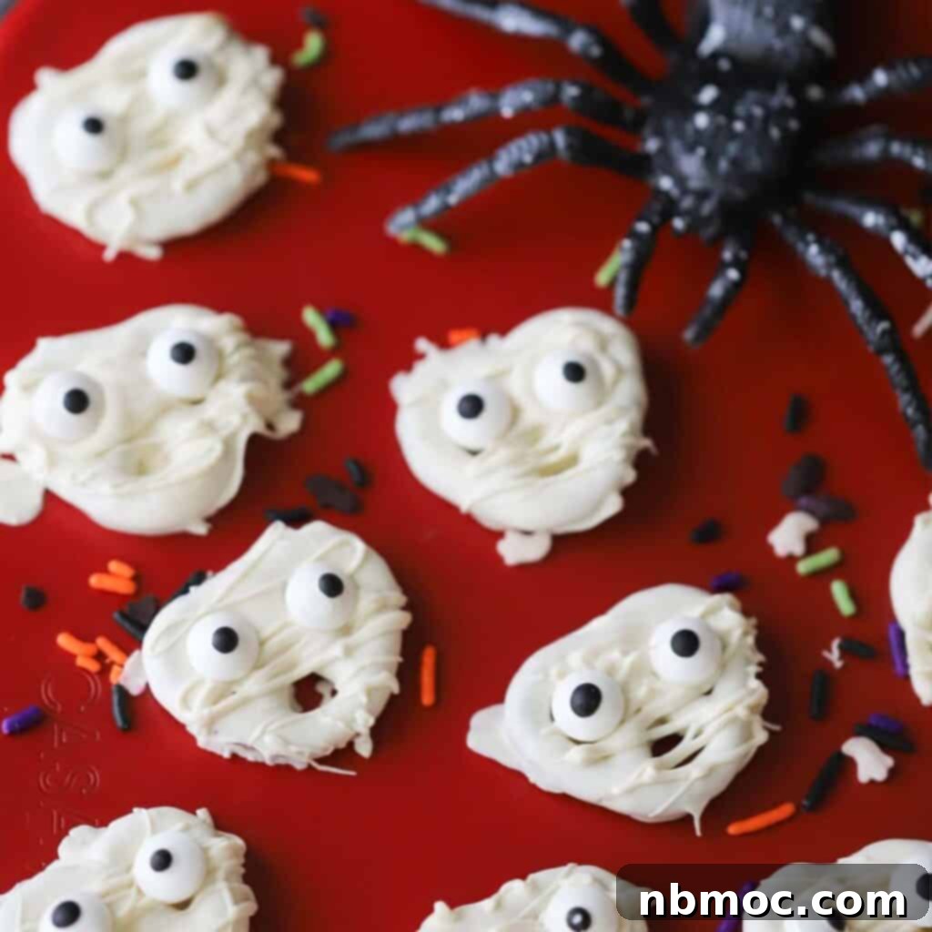 A collection of cute mummy pretzels, each dipped in white chocolate and adorned with festive candy eyes, creating a charming Halloween treat.