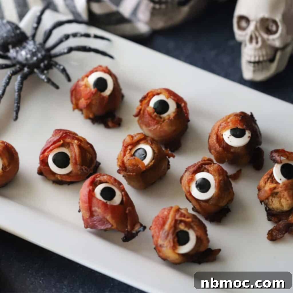 A serving plate laden with Halloween cyclops meatballs, a top favorite among Halloween menu ideas, each boasting a whimsical candy eye for a spooky touch.
