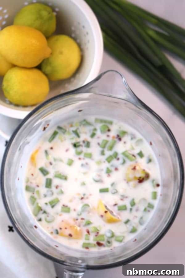 Sticky Teriyaki Salmon Grill 4 A pitcher filled with creamy Buttermilk Ginger Marinade, ready to tenderize salmon, with fresh lemon wedges on the side for making grilled teriyaki salmon.