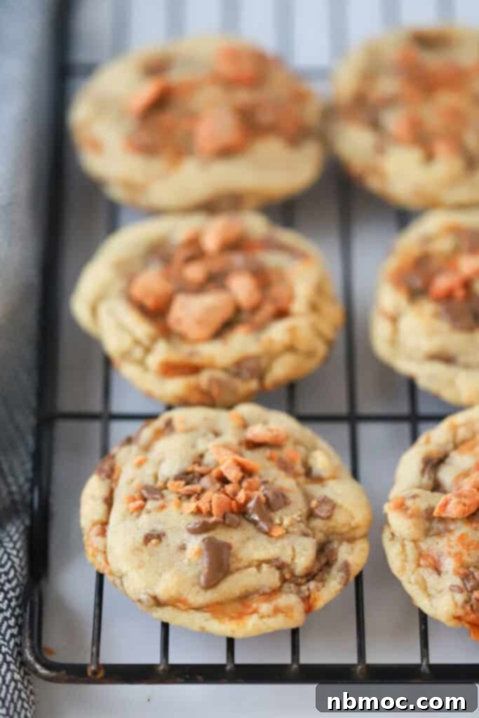 A wire rack full of cookies made with butterfingers candy bars.