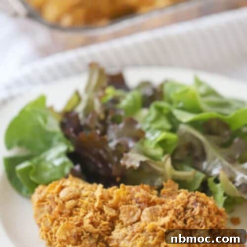 Cornflake fried Chicken on a dinner plate with a green salad, ready to eat.