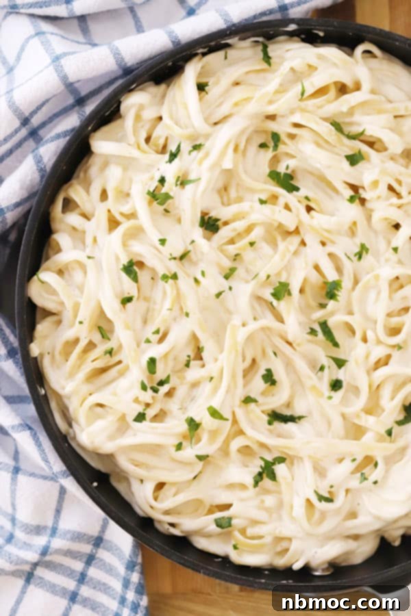 Quick Creamy Alfredo 4 A bowl of easy homemade fettuccine Alfredo topped with fresh chopped parsley, ready for dinner.