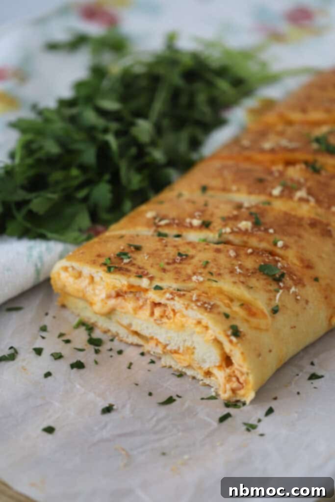 Buffalo Chicken Turnover 2 A baking sheet with buffalo chicken stromboli missing a slice.