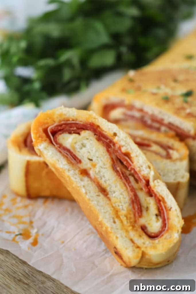 Homemade stromboli filled with cheese and meat, sliced into pieces.