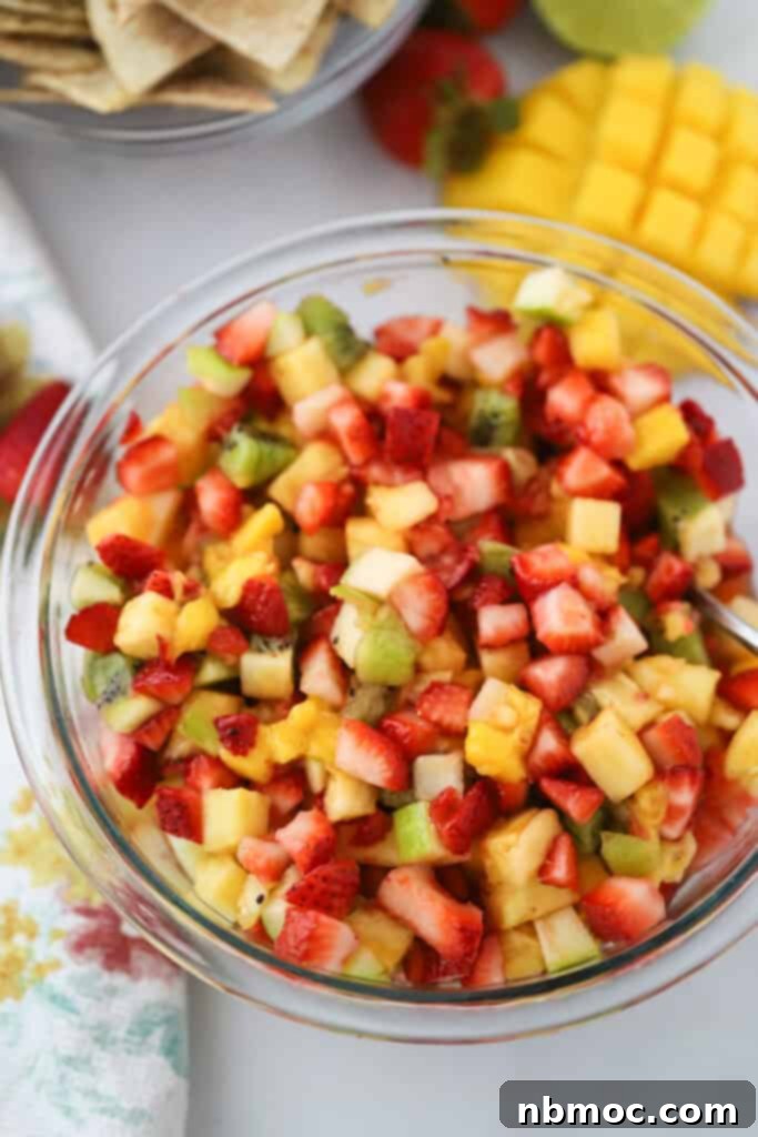 Fruity Fiesta Dip 2 A bowl full of this fruit salsa recipe with strawberries, kiwi, pineapples, and mangos.