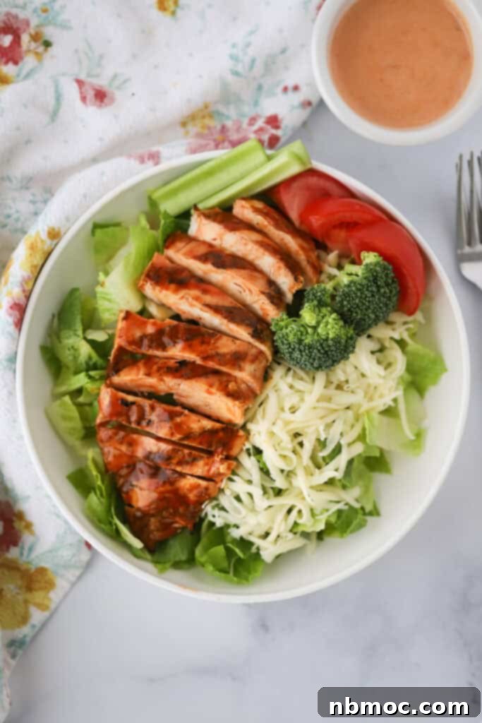 Bold Buffalo Chicken Salad 2 Grilled buffalo chicken salad recipe on a white dinner plate.