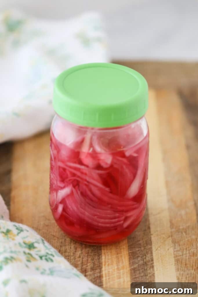 A jar full of quick pickled red onions, ready to be served.