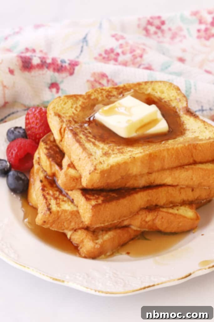 A plate with a stack of french toast topped with butter and syrup.