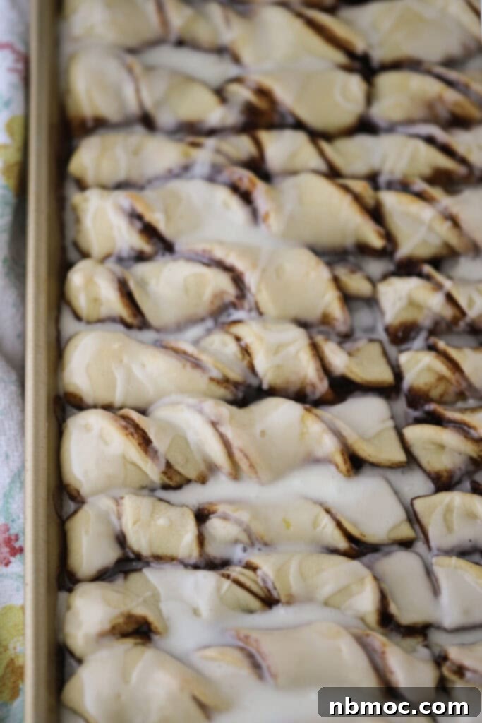 Decadent Cinnamon Twists 5 Rows of beautifully twisted cinnamon breadsticks, golden brown and perfectly baked, arranged neatly on a sheet pan.