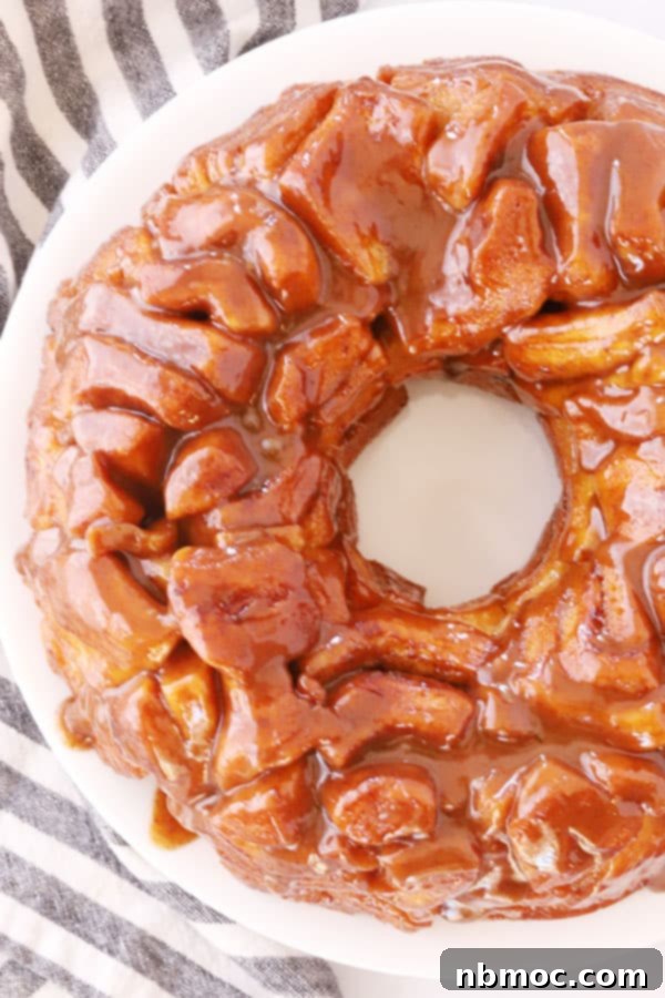 Quick and Easy Monkey Bread 2 Golden-brown monkey bread baked in a bundt pan, generously covered in glistening caramel sauce, ready to be served.