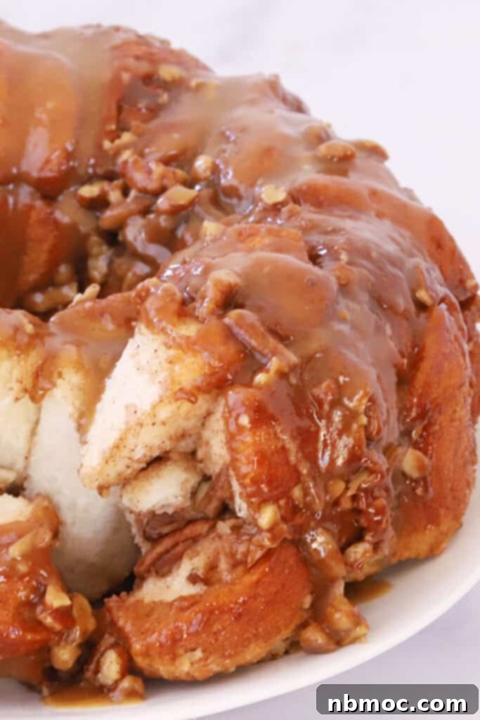 Gooey Caramel Pecan Pull-Apart Bread 2 Best caramel pecan Monkey bread covered in caramel sauce on a plate, ready to be served.