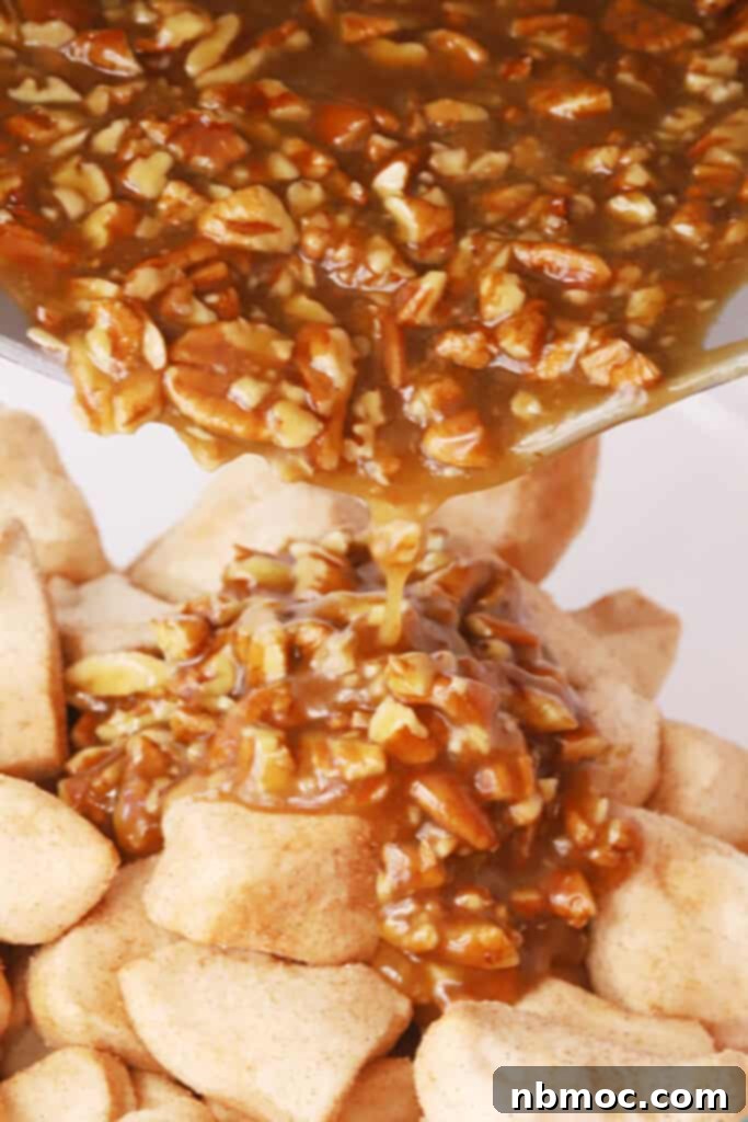 Gooey Caramel Pecan Pull-Apart Bread 4 Pouring homemade pecan caramel sauce over cinnamon-sugar-coated biscuits in a bowl.