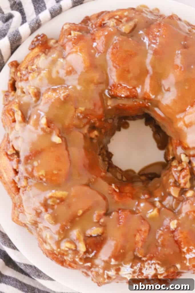 Gooey Caramel Pecan Pull-Apart Bread 6 Caramel pecan monkey bread freshly baked in a bundt pan, resting on a white plate.