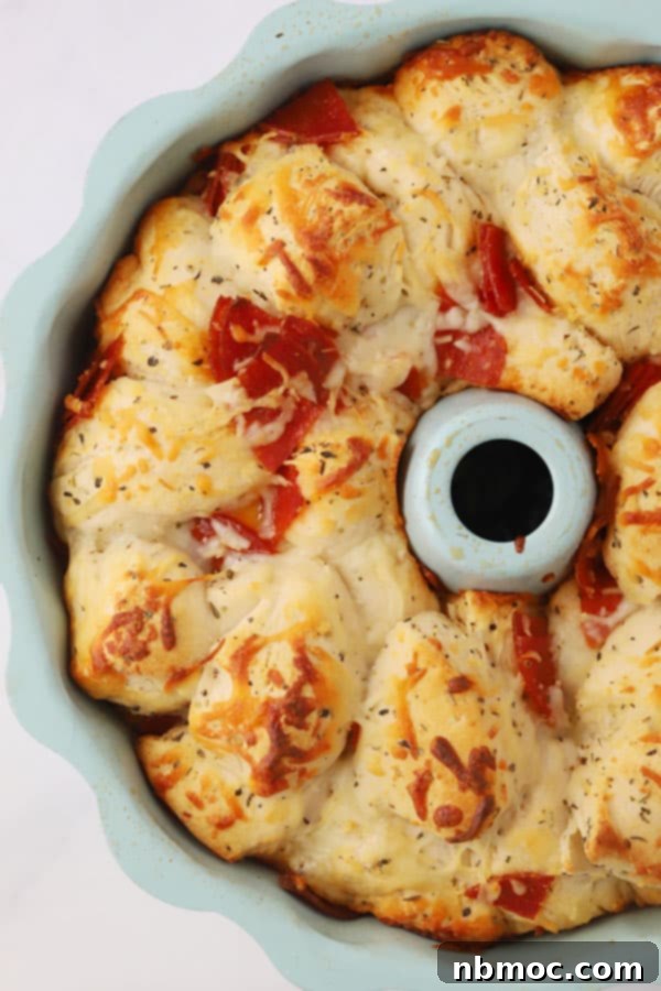 Golden-brown Pizza Monkey Bread baked to perfection in a bundt pan, ready to be inverted and served.