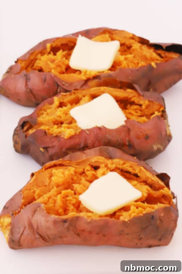 Golden Air Fryer Sweet Potatoes 2 Air fryer baked sweet potatoes split open and topped with melting butter and a drizzle of honey, ready to be served as a delightful side dish.
