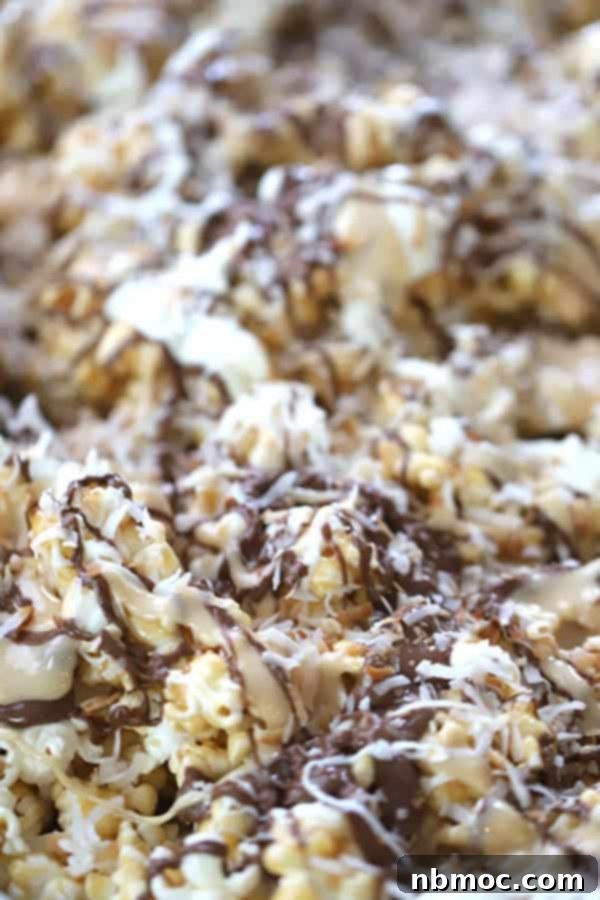 Coconut marshmallow caramel popcorn topped with chocolate drizzle, arranged on a serving plate.