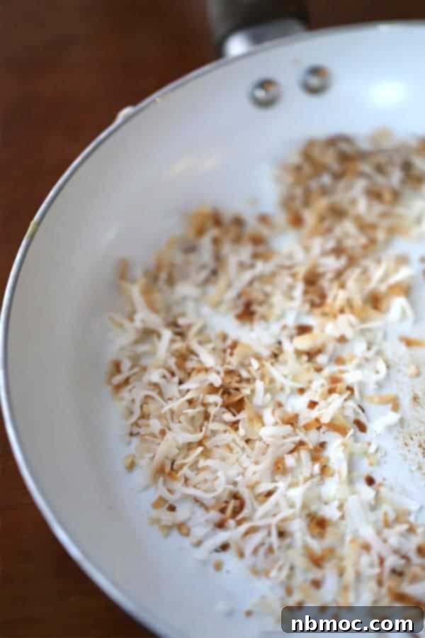 Shredded Coconut in a pan getting toasted to a golden brown.