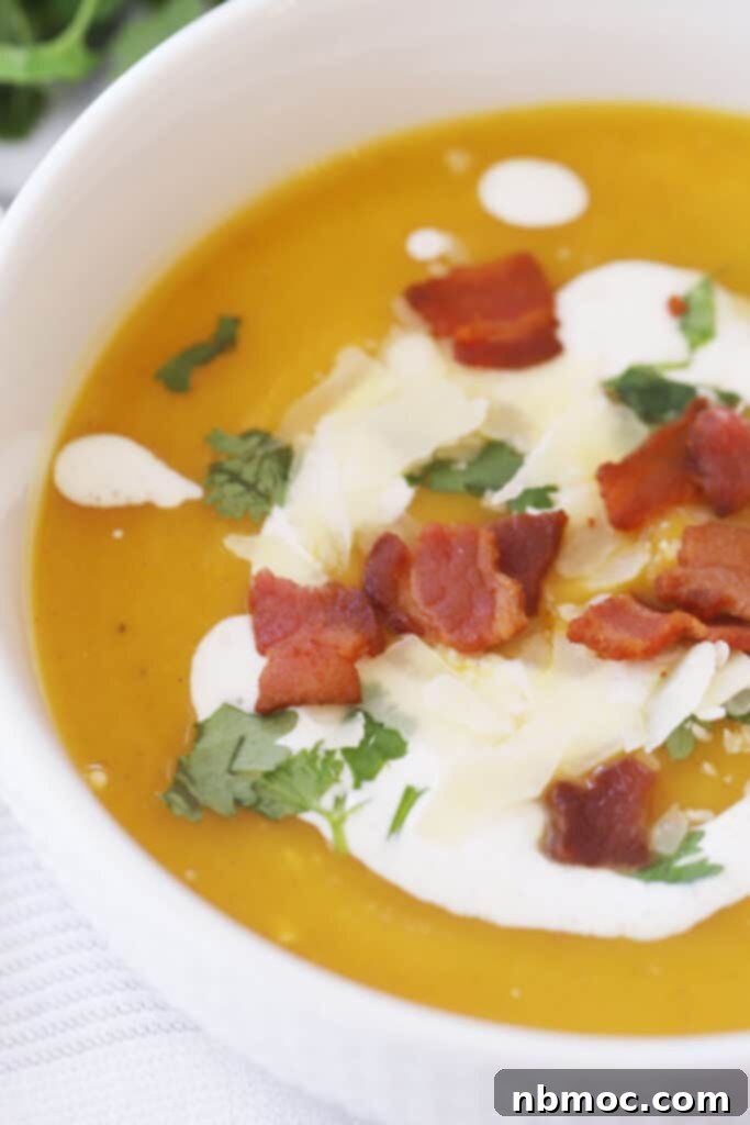 best squash soup recipe in a blue bowl with a creme fresh drizzle on top.