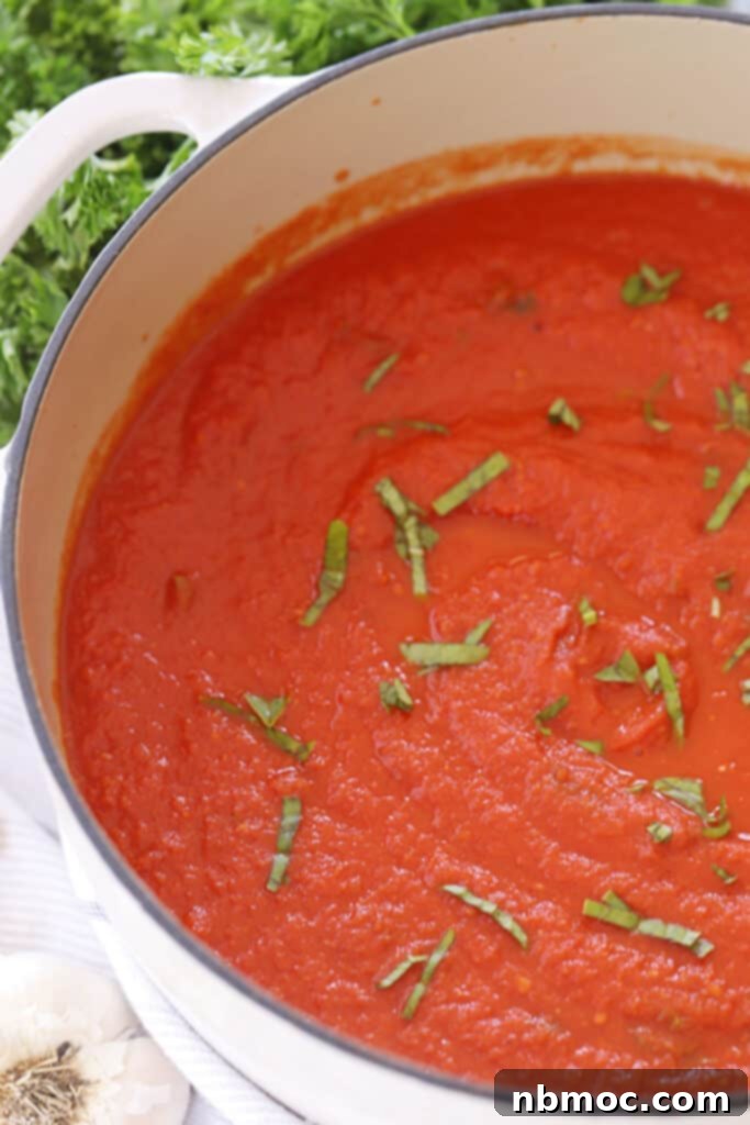 Slow Roasted Garden Tomato Marinara 2 A dutch oven full of thick and rich homemade marinara sauce, simmering with fresh tomatoes.