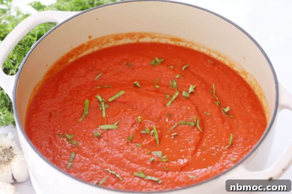 Slow Roasted Garden Tomato Marinara 8 Homemade marinara sauce in a pot topped with fresh basil, ready to serve.