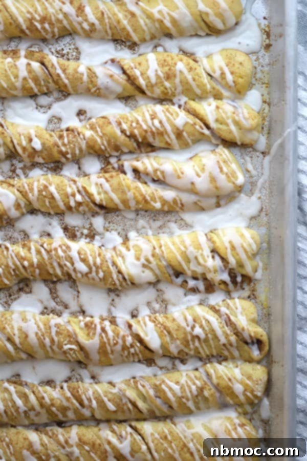 Close-up of Einkorn Cinnamon stick bread with vanilla glaze, resembling cinnamon roll twists, on a sheet pan.