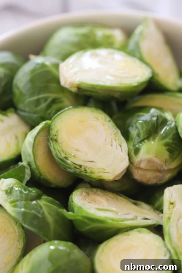 Golden Roasted Brussels Sprouts 3 Brussels sprouts that are cut in half and ready to season on a cutting board.