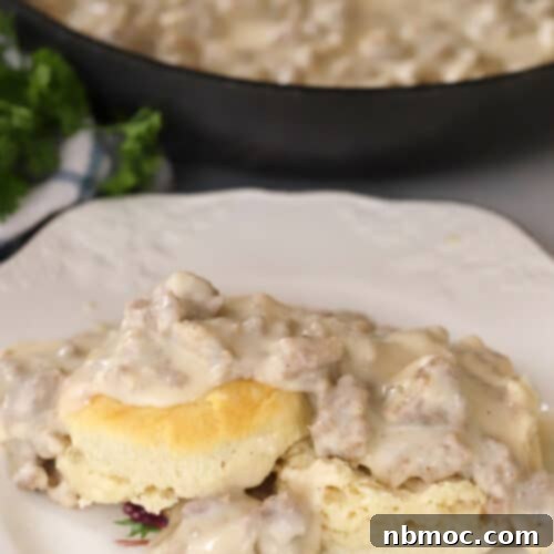 A delicious plate of homemade sausage gravy served over warm, fluffy biscuits.