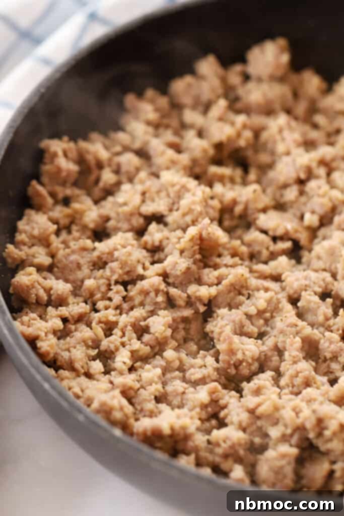 Perfectly browned sausage sizzling in a pan, ready for gravy preparation.