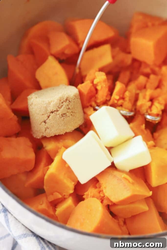 sweet potatoes cooked, drained and butter melting on top, using the potato masher to mash with brown sugar.