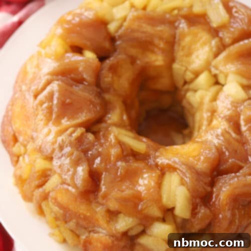 Warm Spiced Apple Monkey Bread 6 Apple Cinnamon Monkey Bread on a white plate, showcasing its caramel glaze and apple chunks.