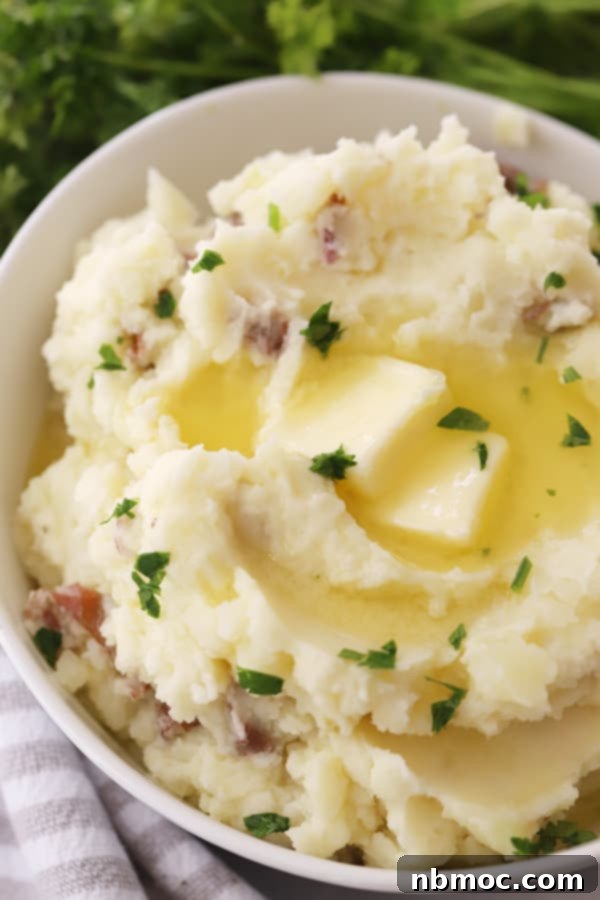 Ruby Red Mashed Potatoes 2 A large white bowl brimming with fluffy, creamy mashed red potatoes, garnished beautifully and ready to serve.