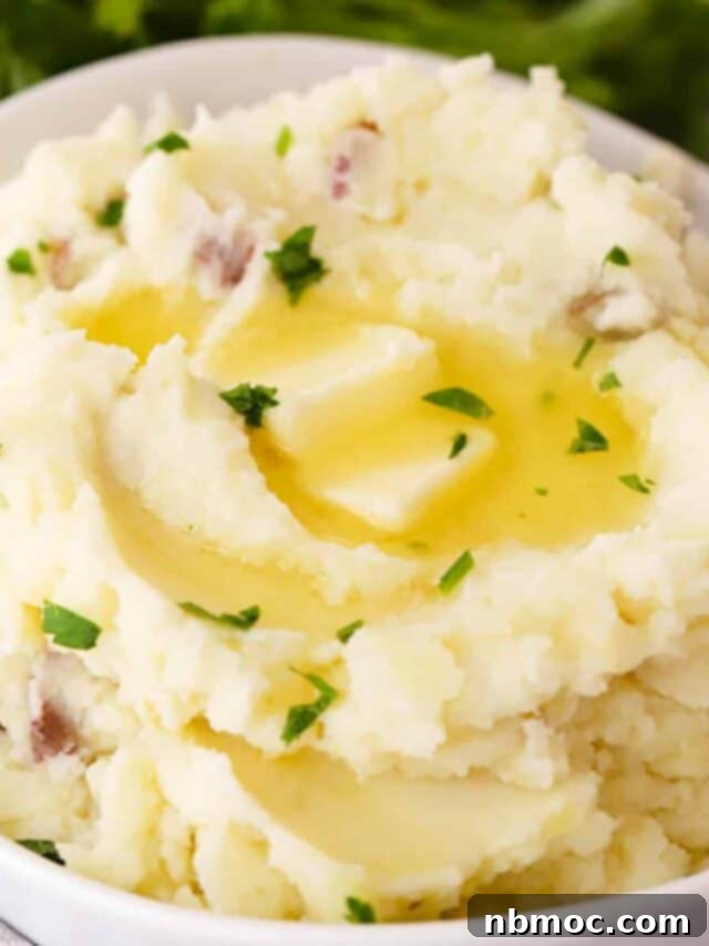 Ruby Red Mashed Potatoes 4 A generous serving of creamy mashed red potatoes in a pristine white bowl, garnished and ready to be enjoyed.